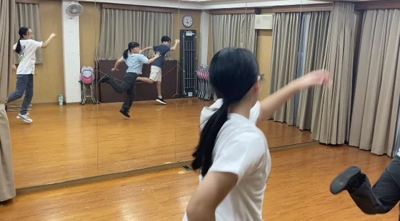 鏡のあるスタジオでダンスを練習する様子