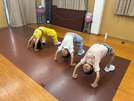 スタジオの床で体を伸ばす子どもたち