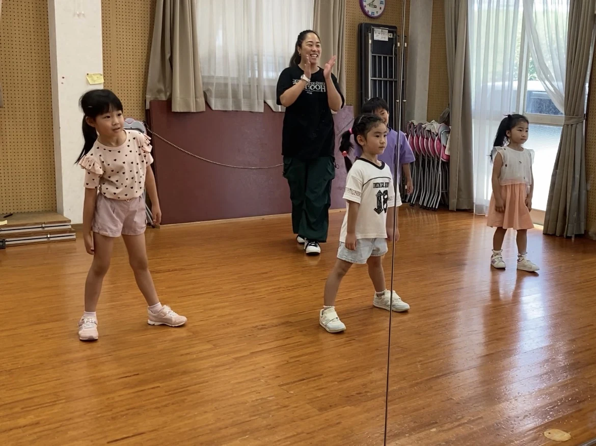笑顔の講師と一緒にレッスンに取り組む子どもたち